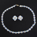 BIJUTERIAS, conjunto com três (3) itens: 1 gargantilha e 2 (par) brincos, confeccionados com contas em vidrofacetado, incolores e azuis, medindo a maior peça 36 cm comprimento, sinais de uso, vide foto.