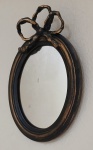 Espelho em madeira oval patinado em madeira negro e dourado com laço 35x24.