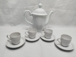 Jogo de bule com 4 xícaras de café em porcelana branca. Medindo o bule 22,5cm de altura. Bule com bicado na borda e na ponta do bico.