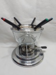 Panela de fondue com rechaud em metal prateado e recipiente em vidro. Medindo 17,5cm de diâmetro x 20cm de altura total