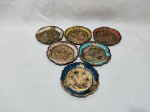 Jogo de 6 descansos de copo em madeira veneziana colorida com ouro. Medindo 10cm de diâmetro.