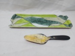 Travessa retangular em porcelana pintada e espátula em casca de tartaruga. Medindo a travessa 39,5cm x 13,5cm.