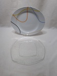 Lote de 2 pratos de bolo, sendo 1 em porcelana e 1 em vidro. Medindo o maior 31cm x 26cm.