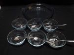 Lote de travessa redonda funda e 6 cumbucas em vidro com colheres em aço inox. Medindo 25cm x 4,5cm de altura.