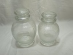 Par de potes de condimentos em vidro moldado. Medindo o maior 13cm de bojo x 21cm de altura.