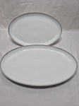 Par de travessas redondas rasas em porcelana Steatita com friso prata. Medindo a maior 42,5cm x 26cm.