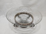 Centro de mesa, fruteira em cristal lapidado com pé em metal prateado trabalhado com relevos. Medindo 33cm x 16,5cm de altura. Leve bicado.