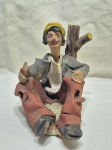 Escultura de homem sentado com seu cachimbo em terracota pintada. Medindo 14cm de altura.