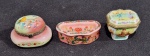 SET DE TRÊS CAIXAS PORTA COMPRIMIDOS DE COLEÇÃO EM PORCELANA E METAL. MEDINDO A MAIOR 4 X 3.5 X 5.5 CM E A MENOR 2 X 2.5 X 6 CM