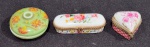 SET DE TRÊS CAIXAS PORTA COMPRIMIDOS DE COLEÇÃO EM PORCELANA E METAL. MEDINDO A MAIOR 3 X 5 CM E A MENOR 2.5 X 4 X 4 CM