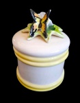 Grande pote de porcelana WEISS pintada a mão e com tampa adornada por florais e borboleta. Medida 12,5 cm de diâmetro e 16,5 cm de altura. Apresenta discreto bicado na parte inferior da base e craquelados naturais do tempo.