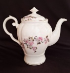 Delicado bule de café em porcelana, de manufatura Real São Paulo, com decoração floral e filetes em dourado. Apresenta dois imperceptíveis lascados na parte interna da peça. Medidas 18 cm.