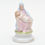 Pietá - arte sacra  em porcelana (possivelmente europeia) policromada , base circular decorada com filete dourado. Base numerada. Leve desgaste do tempo. 9x5,5x4 cm.