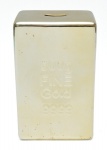 Cofre em Porcelana  Formato Barra de Ouro 500 g Fine Gold 9999,  decorativo  modelado no formato de uma barra de ouro e recoberto por pintura dourada monocromática de forte brilho, conferindo aspecto metálico realista. As inscrições em relevo 500 g / FINE Gold / 9999 reproduzem com fidelidade o visual de lingotes de ouro. De grande impacto visual, ideal para decoração temática, ambientes descontraídos ou coleções de objetos inspirados no universo financeiro e pop decor. 24x15x10 cm