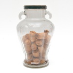 Recipiente decorativo em vidro transparente, de corpo bojudo e base circular, provido de duas pequenas alças laterais ao bojo e tampa.  Interior decorado com rolhas de cortiça. Marcas do tempo. 30x20 cm diam.