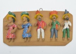 Grupo escultórico de arte popular em barro modelado e policromado, composto por seis figuras etnográficas dispostas lado caracterizados por trajes típicos, chapéus e expressões estilizadas. Verso assinado Leonardo. 18x10 cm