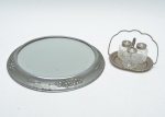 Lote contendo: bandeja circular com espelho central em metal, borda com decoração floral em relevo, acompanhada de galheteiro contendo três recipientes de vidro prensado. Marcas do tempo.  31 cm diam (bandeija).