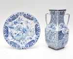 Lote contendo  ânfora com forma arquitetônica, a decoração é ricamente trabalhada em azul  combinando painéis geométricos, motivos florais estilizados e arabescos, organizados em campos bem delimitados, de clara inspiração orientalizante. O prato complementar exibe ampla composição floral com delicados efeitos de sombreamento e movimento. 25x18 e 25 cm diam