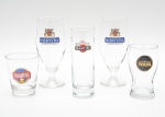 Conjunto composto por cinco copos em vidro transparente, de formatos e capacidades variadas, todos com aplicações serigrafadas originais de marcas de cervejas consagradas. Peças de caráter publicitário, produzidas para uso promocional e colecionável. Maior 17x7 cm