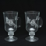 Elegante par de copos em vidro transparente, próprio para Irish Coffee, alça lateral integrada e base elevada em pedestal. Apresentam decoração fosca acidada com motivos florais. Fundo marcado Portugal. 15x10 cm