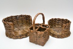Conjunto composto por três cestos artesanais em fibra vegetal trançada. Dois cestos circulares abertos, de dimensões distintas E um cesto menor de formato retangular, com divisórias,  provido de alça fixa arqueada, com trama mais fechada nas laterais e acabamento superior reforçado.30x16 / 21x13 e 25x14x15 cm