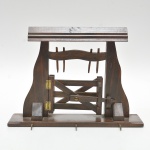 Porteira  em madeira maciça, de feitura artesanal com porteira articulada, travamento funcional em cruzamento de ripas, presa por dobradiças metálicas aparentes. Na base frontal, apresenta três ganchos metálicos destinados à suspensão de chaves ou pequenos . 28x21x6 cm