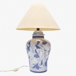 Abajur em porcelana, corpo bojudo, decorado com policromia azul sobre fundo branco, apresentando composição de volutas e folhagens estilizadas. Necessita revisao na fiação. Marcas de uso. 51x27 cm.