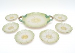 Jogo de sobremesa em cerâmica vitrificada, apresentam esmaltagem em tom verde-claro suave, com detalhamento em dourado, composto por bandeja oval com alças vazadas e seis pratos individuais, todos modelados em delicado formato de pétalas florais. 30 e 15 cm diam. Total 7 pçs. Fundo marcado ceramica INCA