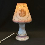 Delicado abajur em porcelana, anos  1950 /60. Corpo e cúpula inteiramente em porcelana esmaltada, com decoração policromada de cena galante em estilo romântico, inspirada no século XVIII, emoldurada por frisos florais dourados. Cúpula vazada com pequenos pontos translúcidos, permitindo a passagem suave da luz . Peça decorativa de caráter clássico. 27x12 cm. Fiação revisada e funcionando.