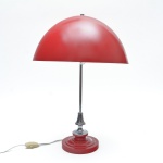 Red Mushroom Lamp - Luminária de mesa de desenho icônico, conhecida como Red Mushroom, caracterizada pela cúpula hemisférica em vibrante tom vermelho, de superfície lisa e contínua, que remete à silhueta orgânica. A haste central em metal apresenta refinados acabamentos cromados, com transições suaves entre volumes torneados que valorizam o brilho espelhado e conferem sofisticação ao conjunto, base circular e escalonada. Fiação revisada e funcionando. 52x36 cm