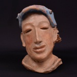 Imponente escultura de modelagem manual e acabamento rústico, retratando um  rosto sereno e introspectivo, com olhos semifechados e um leve sorriso.  Traços faciais simplificados, enfatizando a estética espontânea e expressiva da ARTE POPULAR. Artista desconhecido. 26x22x17 cm. Peso 3.086 klgr