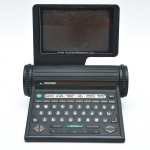 ROLODEX  The Electrodex Plus, organizador eletrônico de contatos, c. 1990.Plástico rígido preto, tela basculante, teclado alfanumérico e memória interna de 64K. Funções de agenda, contatos, lembretes, calendário e calculadora. Acompanha fita original, caixa original e manual. Não testada sem garantias, ausencia da fonte. Tambem funciona a pilha  20x20x20 cm.