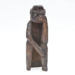 Escultura em madeira, representando figura masculina , de caráter totêmico e linguagem arcaizante. A figura apresenta corpo compacto, o rosto é esquematizado, com feições angulosas e expressão grave. No verso, observa-se a presença de uma serpente entalhada ao longo das costas da figura, elemento simbólico de grande relevância histórica e antropológica, em diversas culturas  indígenas, africanas e afro-brasileiras. 40x14x14 cm