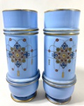 OPALINA FRANÇA , SÉC. XIX - Exuberante par de vasos em OPALINA  azul celeste, com elegante forma cilíndrica e base arredondada. Decorados em esmaltes policromados e douração, exibem ao centro delicados motivos florais em roseta estilizada, realçados por arabescos dourados e aplicações em esmalte pontilhado nas cores vermelho, verde e azul, em fino trabalho esmaltado conhecido como jewel decoration.  As bordas e anéis são sublinhados com filetes de ouro.  Peças como estas, eram produzidas na França no SÉCULO XIX, e destinadas a interiores aristocráticos. Medidas:  30 cm de altura x 11 cm de bocal