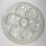 PRATO DE VIDRO PRENSADO  PARA OSTRA- PRATO EM VIDRO TRANSPARENTE PRENSADO, FORMATO REDONDO COM SEIS CAVIDADES E CENTRO REBAIXADO, BORDA PEROLADA - AO GOSTO DE LALIQUE -  DECORAÇÃO EM RELEVO VIDRO GROSSO, TRANSPARENTE, DE BRILHO LIMPO E COR UNIFORME . MEDIDAS: 26 CM