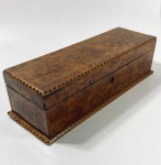 CAIXA RETANGULAR EM RAIZ DE NOZ E MARQUETERIA, INGLATERRA, SÉC. XIX - ELEGANTE CAIXA RETANGULAR EM MADEIRA REVESTIDA POR FOLHEADO DE RAIZ DE NOZ (BURR WALNUT), COM DELICADA MARQUETERIA GEOMÉTRICA EM MADEIRA CLARA E ESCURA NAS BORDAS, FORMANDO PADRÃO EM FAIXA. INTERIOR REVESTIDO EM SEDA BEGE JACQUARD, COM TAMPA INTERNA ACOLCHOADA. POSSUI FECHADURA ORIGINAL (SEM CHAVE). ESTILO VITORIANO TARDIO, PRODUÇÃO INGLESA, SÉCULO XIX, PROVAVELMENTE UTILIZADA COMO WRITING BOX OU CAIXA DE GUARDAR JÓIAS/OBJETOS DE ESCRITÓRIO.- MEDIDAS: 9 X 10 X 31 CM