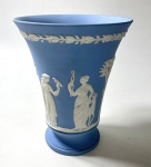 WEDGWOOD- ENGLAND- VASO EM JASPER AZUL E BRANCO COM FIGURAS EM ALTO RELEVO COM MOTIVOS NEOCLÁSSICO, MARCADO EM BAIXO RELEVO NA BASE WEEDGWOOD. MEDIDAS: 15 X 12 CM .CURIOSIDADES: EM 1738 COMEÇARAM AS ESCAVAÇÕES DE POMPEIA E HERCULANO PRÓXIMO DE NÁPOLES NA ITÁLIA CRIANDO A PARTIR DESSA ÉPOCA, NA EUROPA, UM NOVO INTERESSE AO ESTILO NEOCLÁSSICO. EM 1759, JOSIAH WEDGWOOD FUNDOU UMA MANUFATORA DE PORCELANA INSPIRADA EM MOTIVOS DA ANTIGUIDADE CLÁSSICA, TORNANDO SUA EMPRESA CONSAGRADA MUNDIALMENTE. AS PEÇAS ERAM REALIZADAS COM UM TIPO DE MATERIAL AO QUAL FOI DADO O NOME DE JASPER.