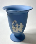 WEDGWOOD - VASO EM JASPER AZUL E BRANCO COM FIGURAS DE DEUSAS GREGAS EM ALTO RELEVO.  REPRESENTANDO  VÊNUS E CUPIDO E NOUTRO LADO, A DEUSA TÉTIS BANHANDO AQUILES SEGURANDO PELO SEU CALCANHAR.  MEDIDAS: 13 X 10 CM . POSSUI UM PEQUENO LASCADO ABAIXO DO BOCAL. CURIOSIDADES: EM 1738 COMEÇARAM AS ESCAVAÇÕES DE POMPEIA E HERCULANO PRÓXIMO DE NÁPOLES NA ITÁLIA CRIANDO A PARTIR DESSA ÉPOCA, NA EUROPA, UM NOVO INTERESSE AO ESTILO NEOCLÁSSICO. EM 1759, JOSIAH WEDGWOOD FUNDOU UMA MANUFATORA DE PORCELANA INSPIRADA EM MOTIVOS DA ANTIGUIDADE CLÁSSICA, TORNANDO SUA EMPRESA CONSAGRADA MUNDIALMENTE. AS PEÇAS ERAM REALIZADAS COM UM TIPO DE MATERIAL AO QUAL FOI DADO O NOME DE JASPER.