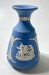 WEDGWOOD ENGLAND - VASO EM JASPER AZUL E BRANCO  COM MOTIVOS EM ESTILO NEOCLÁSSICO, MANUFATURA NO VERSO  EM BAIXO RELEVO . MEDIDAS: 12,5 CM. CURIOSIDADES: EM 1738 COMEÇARAM AS ESCAVAÇÕES DE POMPEIA E HERCULANO PRÓXIMO DE NÁPOLES NA ITÁLIA CRIANDO A PARTIR DESSA ÉPOCA, NA EUROPA, UM NOVO INTERESSE AO ESTILO NEOCLÁSSICO. EM 1759, JOSIAH WEDGWOOD FUNDOU UMA MANUFATORA DE PORCELANA INSPIRADA EM MOTIVOS DA ANTIGUIDADE CLÁSSICA, TORNANDO SUA EMPRESA CONSAGRADA MUNDIALMENTE. AS PEÇAS ERAM REALIZADAS COM UM TIPO DE MATERIAL AO QUAL FOI DADO O NOME DE JASPER.