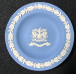WEDGWOOD- ENGLAND - PRATO EM JASPER AZUL E BRANCO DECORAÇÃO DE GUIRLANDAS DE LOURO E BRASÃO CENTRAL REPRESENTANDO ESCUDO DA CIDADE DE LONDRES. MANUFATURA NO VERSO.  MEDIDAS: 11 cm- CURIOSIDADES: EM 1738 COMEÇARAM AS ESCAVAÇÕES DE POMPEIA E HERCULANO PRÓXIMO DE NÁPOLES NA ITÁLIA CRIANDO A PARTIR DESSA ÉPOCA, NA EUROPA, UM NOVO INTERESSE AO ESTILO NEOCLÁSSICO. EM 1759, JOSIAH WEDGWOOD FUNDOU UMA MANUFATORA DE PORCELANA INSPIRADA EM MOTIVOS DA ANTIGUIDADE CLÁSSICA, TORNANDO SUA EMPRESA CONSAGRADA MUNDIALMENTE. AS PEÇAS ERAM REALIZADAS COM UM TIPO DE MATERIAL AO QUAL FOI DADO O NOME DE JASPER.