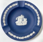 WEDGWOOD- ENGLAND- CINZEIRO EM JASPER AZUL ESCURO E BRANCO DECORAÇÃO DE GUIRLANDAS DE LOURO E MEDALHÃO CENTRAL COM FIGURAS NEOCLÁSSICAS.MANUFATURA NO VERSO EM BAIXO RELEVO. MEDIDAS: 11 CM  CURIOSIDADES: EM 1738 COMEÇARAM AS ESCAVAÇÕES DE POMPEIA E HERCULANO PRÓXIMO DE NÁPOLES NA ITÁLIA CRIANDO A PARTIR DESSA ÉPOCA, NA EUROPA, UM NOVO INTERESSE AO ESTILO NEOCLÁSSICO. EM 1759, JOSIAH WEDGWOOD FUNDOU UMA MANUFATORA DE PORCELANA INSPIRADA EM MOTIVOS DA ANTIGUIDADE CLÁSSICA, TORNANDO SUA EMPRESA CONSAGRADA MUNDIALMENTE. AS PEÇAS ERAM REALIZADAS COM UM TIPO DE MATERIAL AO QUAL FOI DADO O NOME DE JASPER.