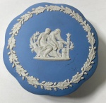 WEDGWOOD- ENGLAND - CAIXA EM JASPER AZUL E BRANCO COM DECORAÇÃO DE GUIRLANDAS DE LOUROS E FIGURAS NEOCLÁSSICAS. MEDIDAS: 13 CM- CURIOSIDADES: EM 1738 COMEÇARAM AS ESCAVAÇÕES DE POMPEIA E HERCULANO PRÓXIMO DE NÁPOLES NA ITÁLIA CRIANDO A PARTIR DESSA ÉPOCA, NA EUROPA, UM NOVO INTERESSE AO ESTILO NEOCLÁSSICO. EM 1759, JOSIAH WEDGWOOD FUNDOU UMA MANUFATORA DE PORCELANA INSPIRADA EM MOTIVOS DA ANTIGUIDADE CLÁSSICA, TORNANDO SUA EMPRESA CONSAGRADA MUNDIALMENTE. AS PEÇAS ERAM REALIZADAS COM UM TIPO DE MATERIAL AO QUAL FOI DADO O NOME DE JASPER.