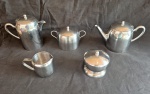 Serviço para chá e café em aço inox composto de bule café medindo 15 cm de altura, bule para chá, leiteira e dois açucareiros sendo um para cubos.