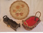 Três peças em madeira sendo bandea redonda policromada medindo 46 cm de diâmetro com desgastes, cesta de madeira para toalhinhas medindo 15 cm por 42 cm por 13 cm e cesta com alças e forração de tecido medindo 26 cm de altura na alça por 45 cm por 25 cm.