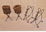 Quatro peças em ferro batido sendo dois porta garrafas de vinho medindo 20 cm por 20 cm por 12 cm e dois porta velas medindo 23 cm por 10 cm de diâmetro.