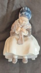 Royal Compenhagen fina escultura em porcelana Dinamarquesa policromada representando camponesa tricotando, medindo 16 cm de altura por 11 cm por 9 cm na base, perfeito estado de conservação.