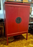 Móvel em madeira de pinus ao gosto Oriental laqueado de vermelho com portas retrateis possivelmente para colocação de aparelagem de som ou tv, medindo 174 cm de altura por 106 cm por 62 cm apresenta minimas falta na pintura e pequeno lascado em um dos pés.