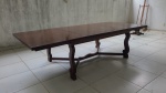 Mesa de banquete em madeira nobre envernizada, Brasil início do século XX, medindo em seu comprimento máximo 76 x 300 x 125cm com as 2 tábuas extras, menor medida do tampo 180 x 125cm, tampo liso ao gosto Art Deco sobre pés de madeira em forma de lira possuindo engrenagem com eixo sem fim para abertura e fechamento do tampo, acompanha manivela em ferro para funcionamento. Retirada em transportadora localizada no bairro de Ramos, somente com agendamento prévio.