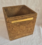 Cachepot década de 60 em madeira compensada revestida em cortiça e com faixasdecorativas em metal amarelo, medindo 26 cm de altura por 27 cm por 27 cm, pequenas faltas na cortiça.