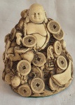 Escultura do Buda da Fortuna em material sintético medindo 13 cm de altura por 11 cm por 11 cm.